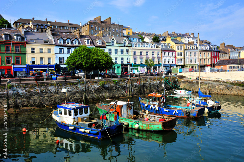Old boats with colorful harbor buildings in background in the port town of Cobh, County Cork, Ireland