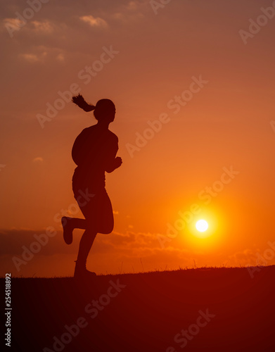 Fototapeta Naklejka Na Ścianę i Meble -  Silhouette of the running girl at sunrise.