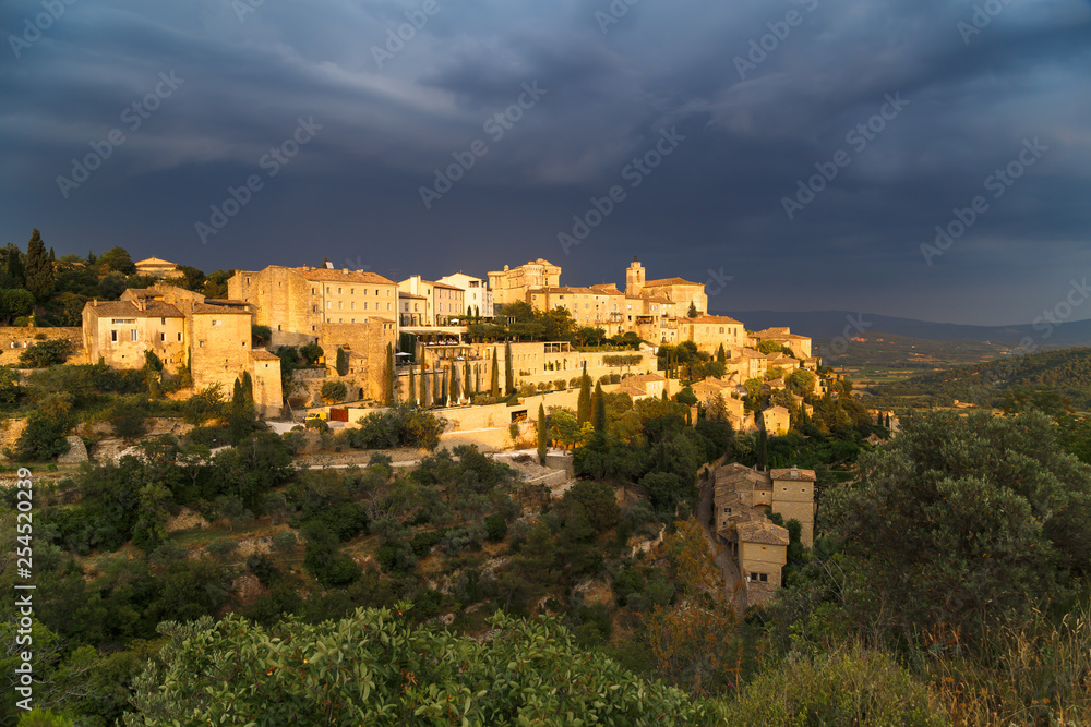 Amazing panoramic view of medieval hilltop village of Gordes before thunderstorm in Provence, France. Travel France.