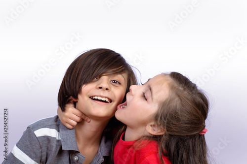 Little girl kissing little boy face.
