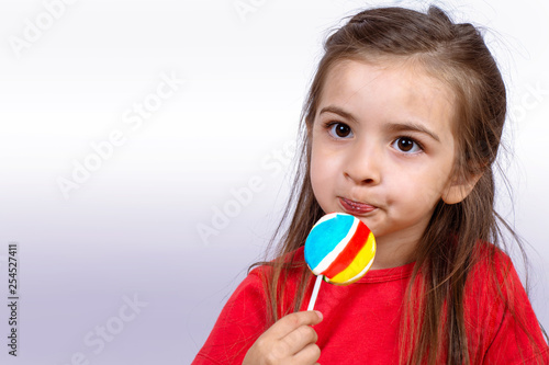 Little girl eating a lollipop.