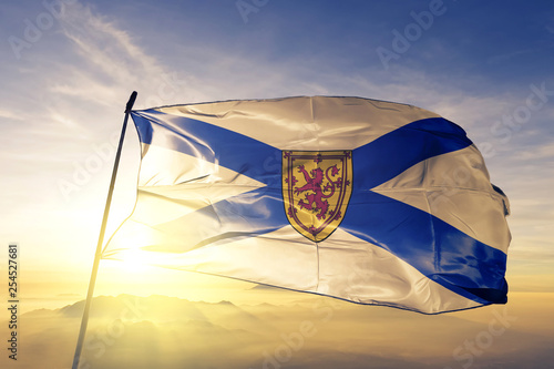 Canvas Print Nova Scotia province of Canada flag waving on the top sunrise mist fog