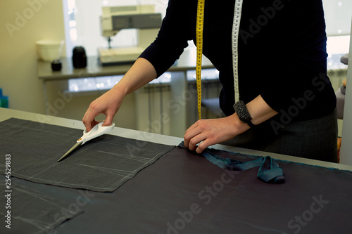 Master cuts fabric. Nesting. Suiting fabric marked with white chalk. Cutting and sewing photo