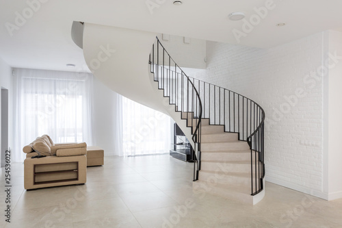 spiral staircase in bright interior with white brick wall in elite expensive apa Fototapeta