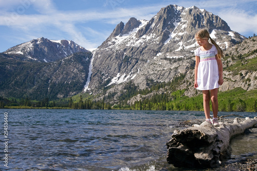 Girl on log on shore of Silver Lake  California