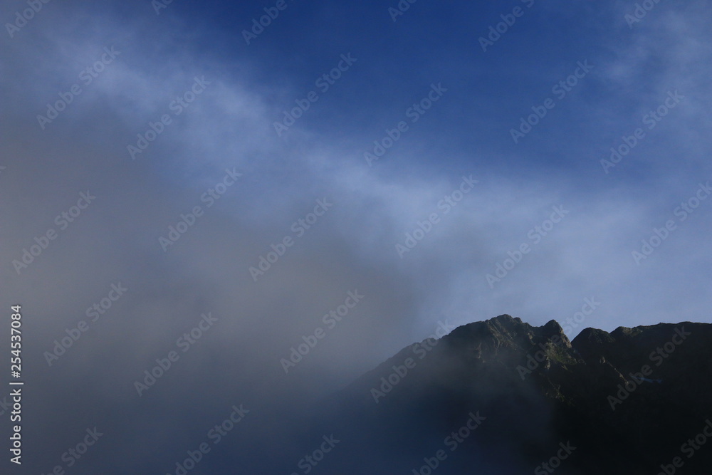 北アルプス　神々しい上高地の朝の風景　雲に煙る穂高連峰と明神岳