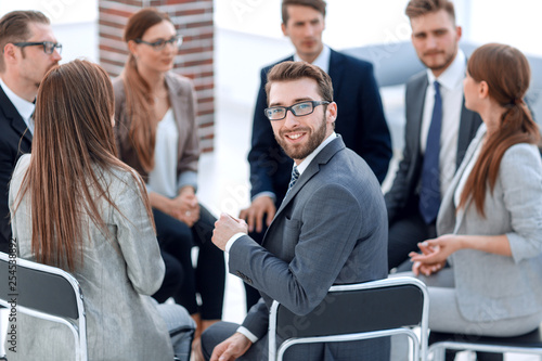 young employee sitting in a circle of colleagues