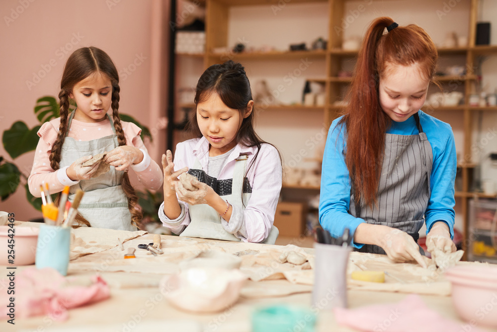 Multi-ethnic group of schoolchildren making handmade ceramics in pottery class - obrazy, fototapety, plakaty 