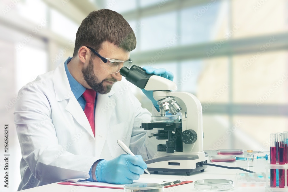 Young male scientist Working with Microscope Young male scientist Working with Microscope