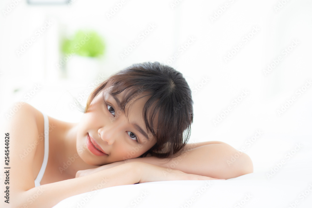 Lifestyle beautiful portrait young asian woman relax lying sleep and smile while wake up with sunrise at morning, girl with happy and fun in the bedroom, health and wellness concept. Lifestyle beautiful portrait young asian woman relax lying sleep and smile while wake up with sunrise at morning, girl with happy and fun in the bedroom, health and wellness concept.