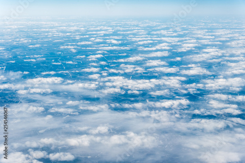 Top view of white clouds above the ground or water