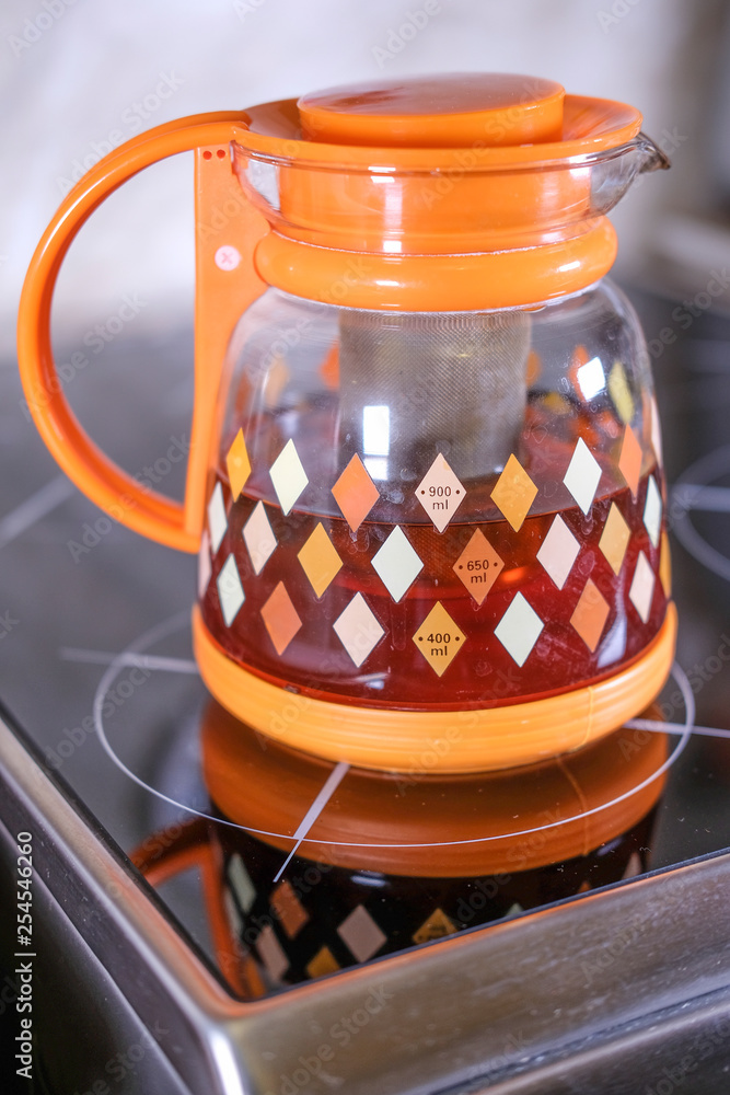 Φωτογραφία the image of the teapot on the ceramic stove