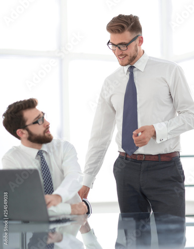 two employees discuss business issues near the office Desk