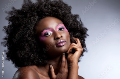 Картината върху платно Afro and Flower beauty with big black hair smooth dark skin  does stunning pose