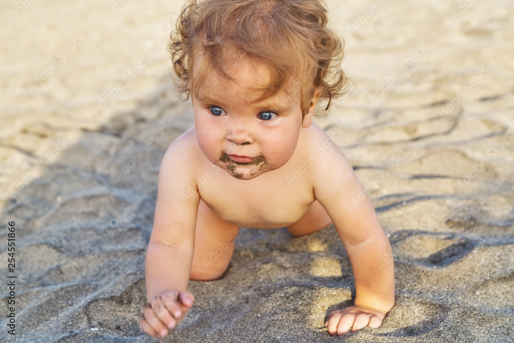 Baby girl crawling in the sand on the beach Baby girl crawling in the sand on the beach