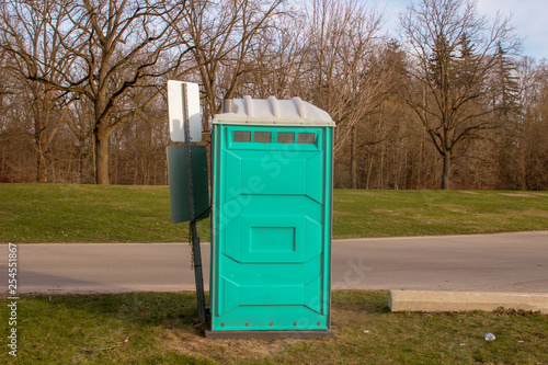 A Dirty, Blue Portable Toilet in a Park, nasty looking place to 