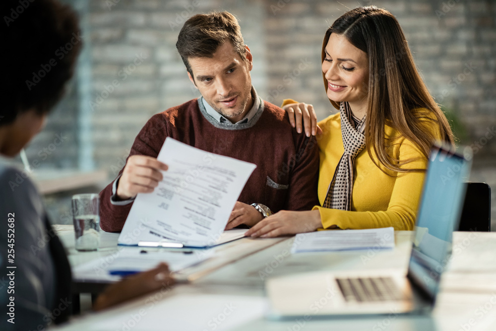 Happy couple going through paperwork on a meeting with insurance agent. Happy couple going through paperwork on a meeting with insurance agent.