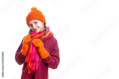 Kids Winter Clothing Ideas. Smiling Caucasian Little Girl In Orange Beanie, Scarf and Mittens.Over Pure White Background.