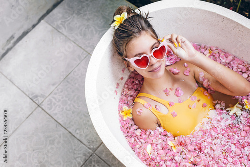 Girl relaxing in spa bath with flowers