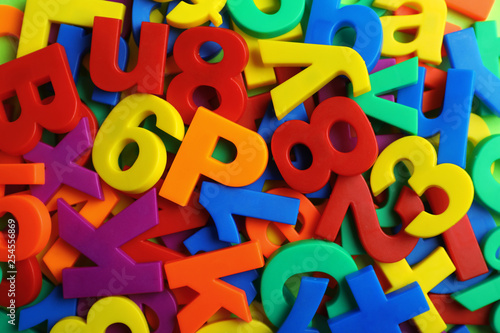 Plastic magnetic letters and numbers as background, top view