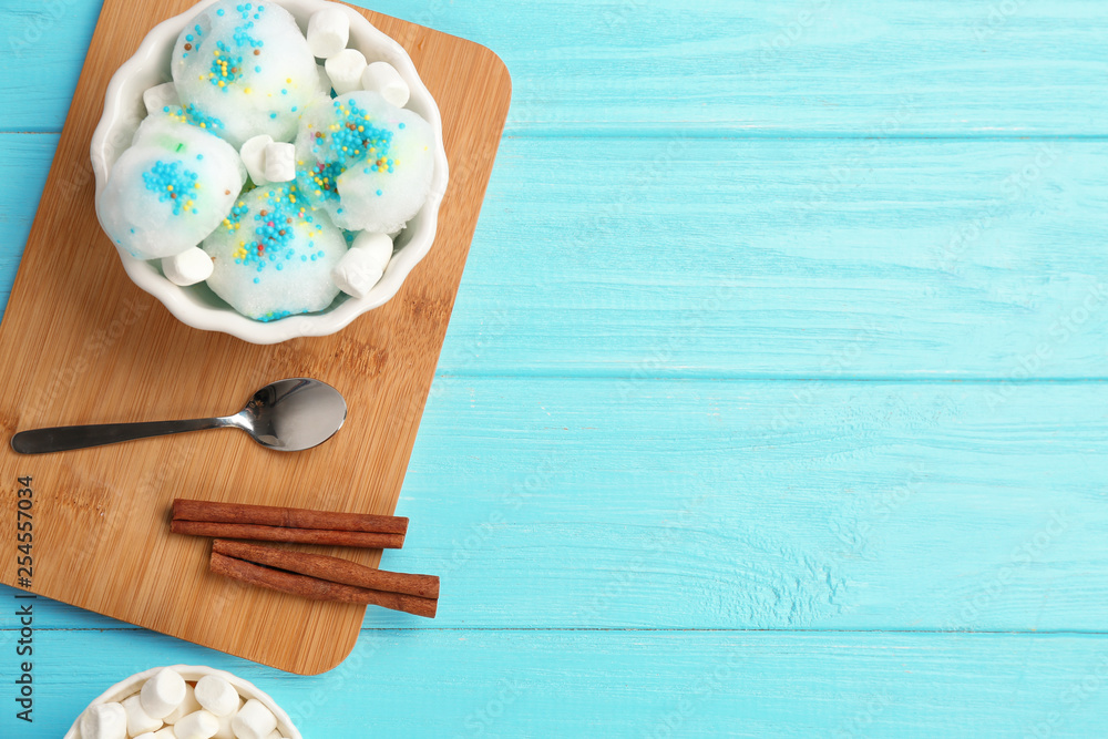 Flat lay composition with snow ice cream in bowl, marshmallows and space for text on color background