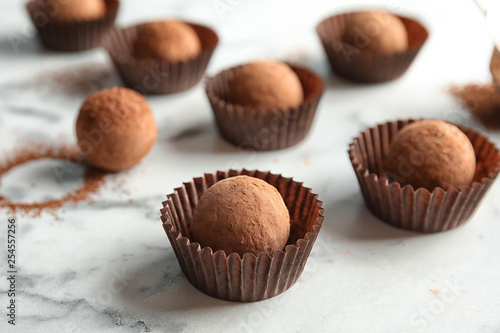 Tasty raw chocolate truffles on marble background