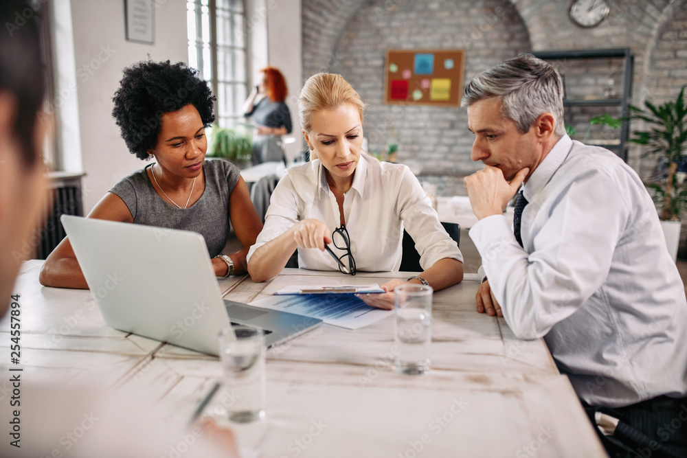 Team of entrepreneurs analyzing business reports on a meeting at the office. Team of entrepreneurs analyzing business reports on a meeting at the office.