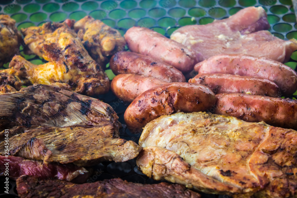 Assorted delicious grilled meat  over the coals on a barbecue.