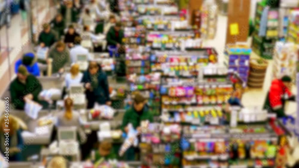 Cashier at supermarket / Retail checkout / Paying groceries. Unrecognizable buyers with carts move in queues to pay for purchases at the supermarket cashier. Cashier at supermarket / Retail checkout / Paying groceries. Unrecognizable buyers with carts move in queues to pay for purchases at the supermarket cashier.