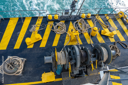 The deck of the ferry boat along with the a thick mooring rope and blue sea water wave, Thailand. Close up