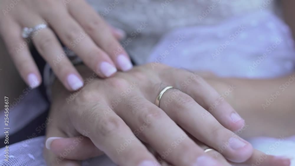 close up of groom and bride gently caress their hands close up of groom and bride gently caress their hands