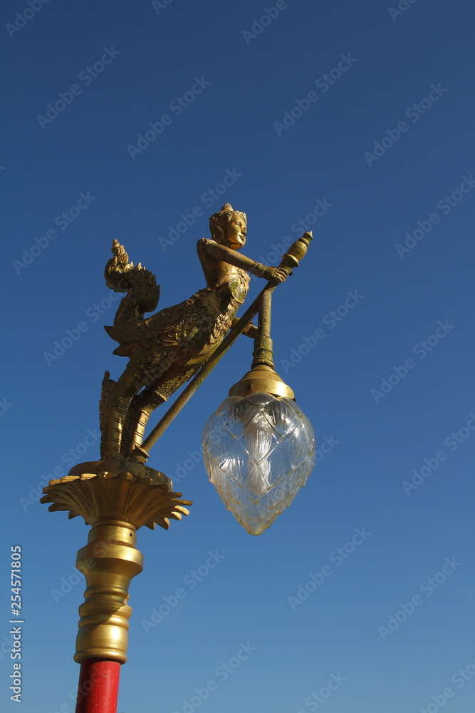 Gold lamps and lighting pole background with a blue sky,at Wat Ban Ngao (Temple), Ranong, Thailand.