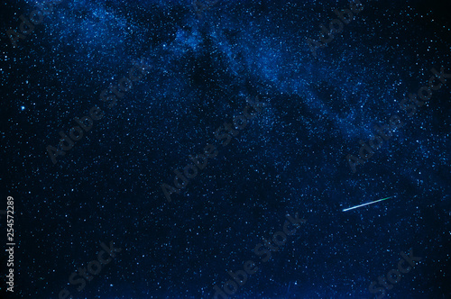 Фотография shooting star in background a starry blue sky