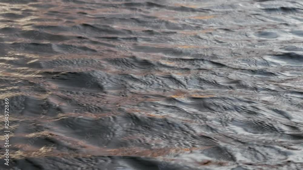 Motion of waves on dark water surface close up. Amazing dramatic natural background. Motion of waves on dark water surface close up. Amazing dramatic natural background.