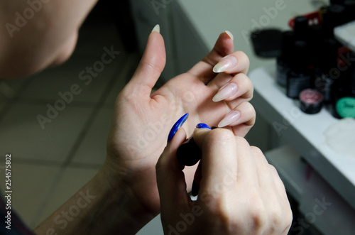 close-up  manicurist  girl paints her nails. manicure