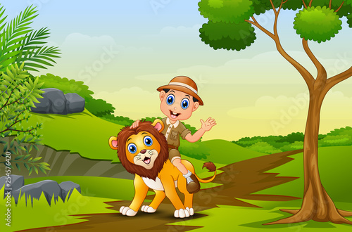 Happy zookeeper boy and lion in a park