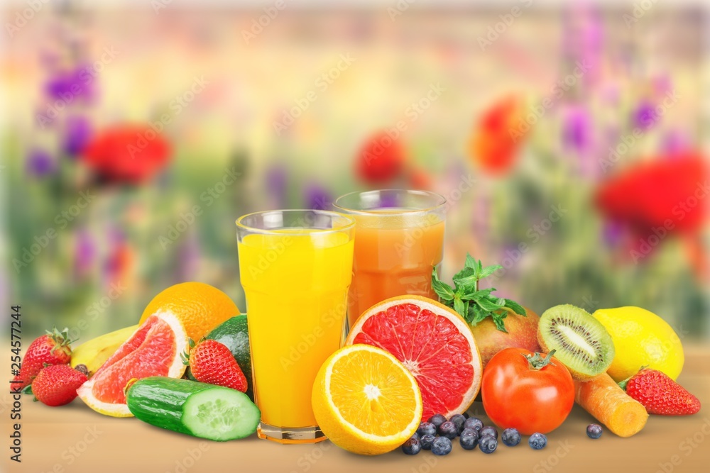 Glasses of fresh juice and fruits with vegetables and measuring tape Glasses of fresh juice and fruits with vegetables and measuring tape