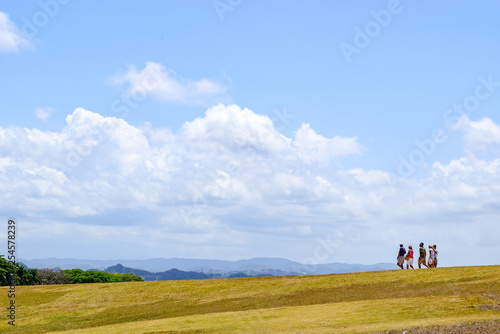 Caucasian adult men and women walking downhill on countryside landscape