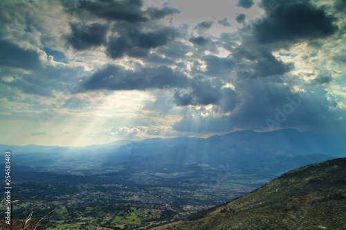 Sun rays through the clouds mountains and valley , in Arcadia Greece.