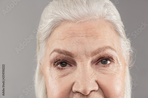 Senior grey-haired lady showing higher part of her face