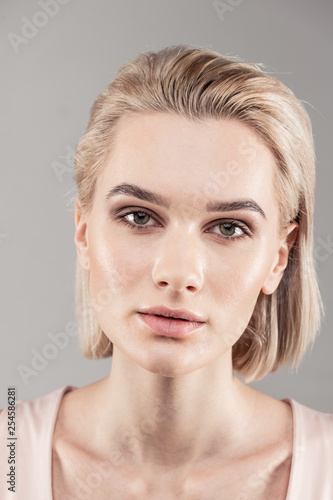 Attractive young lady with short blonde hair posing for cameraman