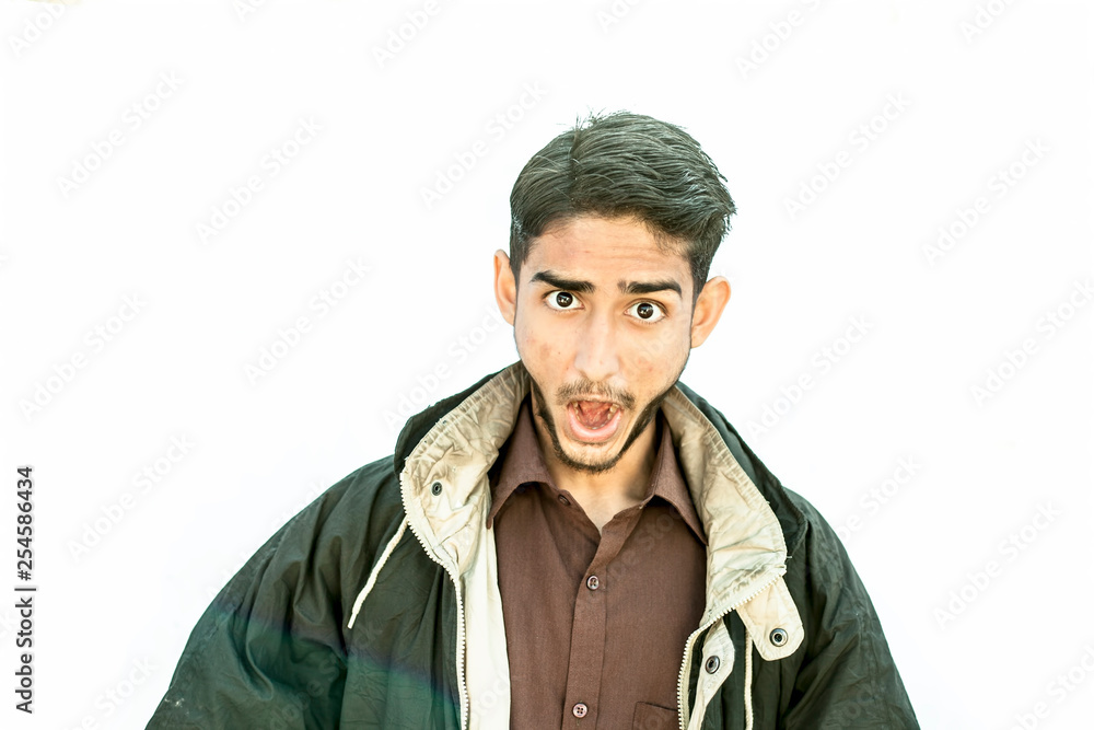 Portrait shot of young male teenager wearing a brown colored shirt with a black colored jacket and expressing doubtfulness or thoughtfulness on his face by collapsing his lips isolated on white.