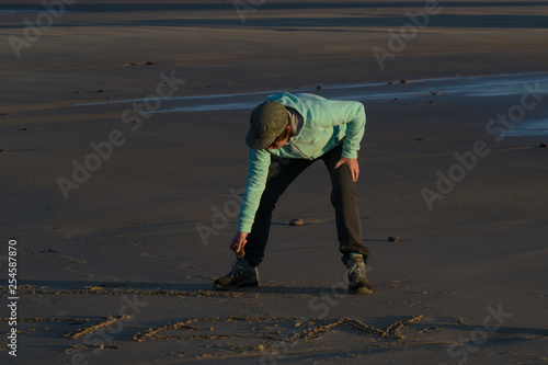 Femme écrivant sur le sable photo