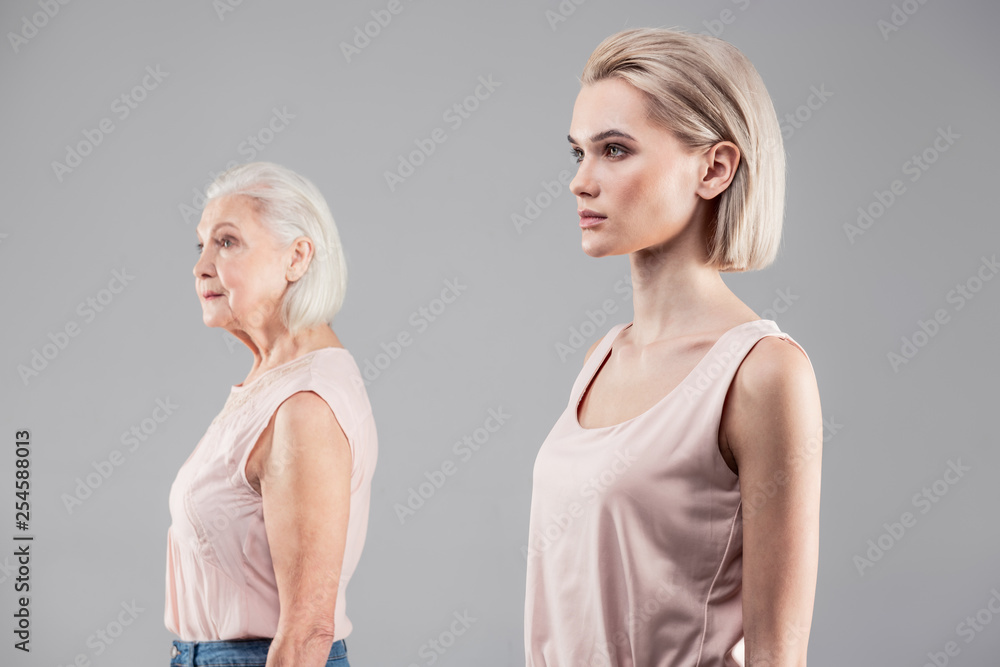 Neutral blonde girl with emotionless face standing on first plan Neutral blonde girl with emotionless face standing on first plan