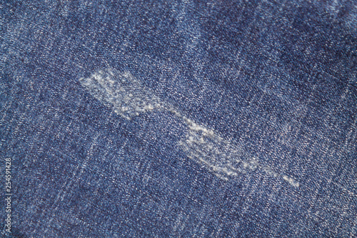 Ripped blue jeans with a hole texture background 