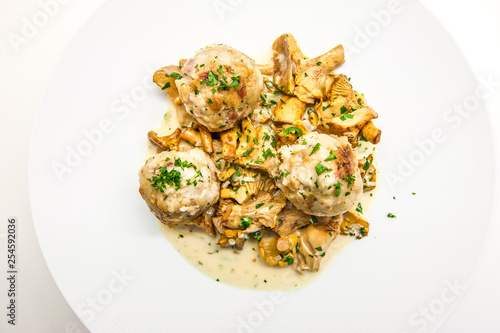 Dumplings with chanterelle ragout on a white plate