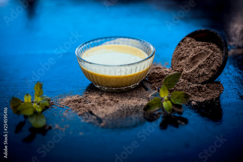 Ayurvedic herb brahmi or Waterhyssop with its beneficial paste ina  glass bowl along with its powder on wooden surface. photo