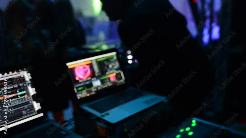 The DJ at the disco is working behind the remote control. Dance floor and light music. The DJ at the disco is working behind the remote control. Dance floor and light music.