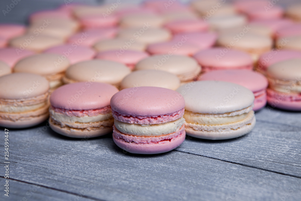 Fototapeta premium Plate of fresh colorful macarons. Raspberry and strawberry pink macarons on soft pastel pink background