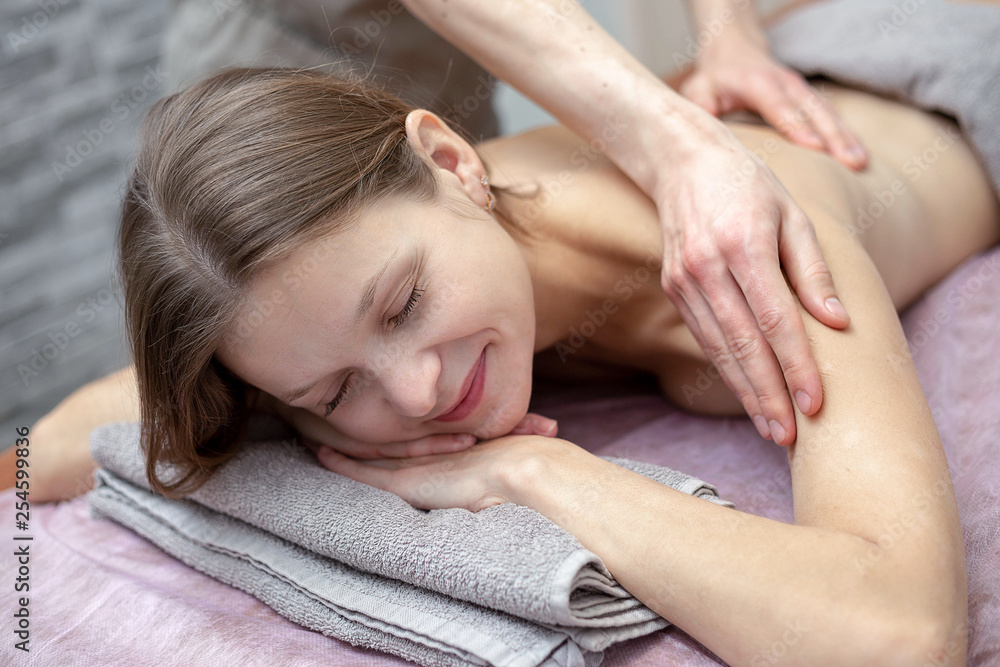 Beautiful young woman is receiving a massage at a massage salon